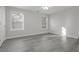 A light and airy bedroom featuring two windows and modern gray wood flooring at 2124 Mitford Ct, Dacula, GA 30019