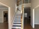 Inviting foyer with wood floors and a staircase leading to the second floor with views into the living room at 2124 Mitford Ct, Dacula, GA 30019