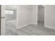 Hallway featuring gray wood floors, neutral paint, and a view into the main room at 2124 Mitford Ct, Dacula, GA 30019