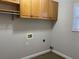 Well-lit laundry room equipped with storage shelves and tile floors at 2124 Mitford Ct, Dacula, GA 30019