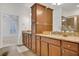 Bathroom with granite countertops, wood cabinets, dual sinks, and a view to the closet and shower at 2752 Middlecreek Way, Cumming, GA 30041