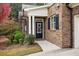 Inviting brick home entrance with a black door, seasonal wreath, and manicured shrubs at 2752 Middlecreek Way, Cumming, GA 30041