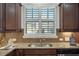 A close up of a kitchen sink with granite countertops and white shutters at 2752 Middlecreek Way, Cumming, GA 30041