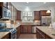 Well-equipped kitchen with stainless steel appliances, granite countertops, and dark wood cabinetry at 2752 Middlecreek Way, Cumming, GA 30041