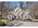 Charming brick two-story home featuring manicured landscaping, a circular driveway, and mature trees at 891 Legacy Woods Dr, Norcross, GA 30093