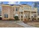 Exterior elevation of a brick home showcasing a deck and patio with lush landscaping at 891 Legacy Woods Dr, Norcross, GA 30093