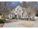 Charming brick two-story home featuring manicured landscaping, a circular driveway, and mature trees at 891 Legacy Woods Dr, Norcross, GA 30093