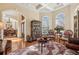 Ornate living room featuring elegant seating, decorative rug, coffered ceiling and large windows at 891 Legacy Woods Dr, Norcross, GA 30093