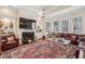 Bright living room with a fireplace, built-in shelving, and multiple windows for natural light at 891 Legacy Woods Dr, Norcross, GA 30093