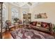 Ornate living room featuring elegant seating, decorative rug, coffered ceiling and large windows at 891 Legacy Woods Dr, Norcross, GA 30093