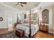 Spacious main bedroom with a four-poster bed, wood floors, decorative ceilings, and ornate furnishings at 891 Legacy Woods Dr, Norcross, GA 30093