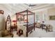 Spacious main bedroom with a four-poster bed, tray ceiling and lots of natural light at 891 Legacy Woods Dr, Norcross, GA 30093