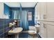 Blue tiled bathroom with a pedestal sink, and white cabinets, offering a clean and fresh look at 1400 Monroe Dr, Atlanta, GA 30324