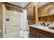 Bathroom features a tub with shower, vanity with countertop, wood paneling and cabinet storage at 4009 Highway 138 Sw, Stockbridge, GA 30281