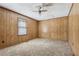 Bedroom with unique paneling, carpeting, a ceiling fan, and a window letting in natural light at 4009 Highway 138 Sw, Stockbridge, GA 30281