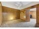 A bedroom with wood paneling, carpeted floors, and an open doorway to another room or closet at 4009 Highway 138 Sw, Stockbridge, GA 30281