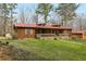 Charming single-story home featuring wood siding, a red metal roof, and a cozy front porch at 4009 Highway 138 Sw, Stockbridge, GA 30281