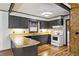 Galley kitchen with a breakfast bar, dark cabinets, white appliances and a view into a laundry area at 4009 Highway 138 Sw, Stockbridge, GA 30281