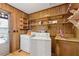 Bright laundry room with washer, dryer, open shelving, and wooden walls at 4009 Highway 138 Sw, Stockbridge, GA 30281