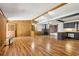 Open-concept living space featuring hardwood floors, a stone fireplace, and a breakfast bar connecting to the kitchen at 4009 Highway 138 Sw, Stockbridge, GA 30281