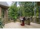Back deck with a grill and lush greenery, perfect for outdoor cooking and entertaining at 1734 Doonbeg Ct, Kennesaw, GA 30152