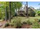 Beautiful backyard featuring mature trees, lush green lawn, and screened in back porch with stairs at 1734 Doonbeg Ct, Kennesaw, GA 30152