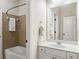 Bright bathroom featuring a shower-tub combo with neutral tile and a white vanity with a large mirror at 1734 Doonbeg Ct, Kennesaw, GA 30152