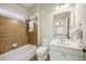 Neutral bathroom featuring bathtub with tile surround and white vanity with mirror and lighting at 1734 Doonbeg Ct, Kennesaw, GA 30152