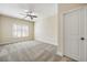 Bright bedroom with neutral carpet, plantation shutters, and a ceiling fan with light fixture at 1734 Doonbeg Ct, Kennesaw, GA 30152