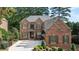 Beautiful two-story brick home with manicured lawn and mature trees in a quiet neighborhood at 1734 Doonbeg Ct, Kennesaw, GA 30152