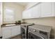 Well-appointed laundry room with granite countertop, cabinets, and modern washer and dryer at 1734 Doonbeg Ct, Kennesaw, GA 30152