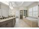 Well-lit primary bathroom featuring double sinks, a soaking tub, and a separate glass shower at 1734 Doonbeg Ct, Kennesaw, GA 30152