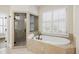 Elegant bathroom featuring a soaking tub and separate shower, enhanced by natural light at 1734 Doonbeg Ct, Kennesaw, GA 30152