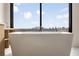 Modern white soaking tub with a view of the city skyline at 2425 Peachtree Ne Rd # 1604, Atlanta, GA 30305