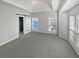 Bedroom with tray ceiling, carpet, large windows, and barn door leading to the bathroom at 4540 Flat Willow Pl, Douglasville, GA 30135