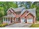 Charming two-story brick home featuring a front porch and two-car garage at 4668 Raiders Ridge Ct, Lithonia, GA 30038