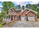 Charming two-story brick home featuring a front porch and two-car garage at 4668 Raiders Ridge Ct, Lithonia, GA 30038