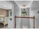 Hallway featuring wood and white banister, with decorative chandelier, leading to bedroom at 4668 Raiders Ridge Ct, Lithonia, GA 30038