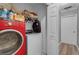 Laundry room featuring a red washing machine, a white dryer, storage shelving, and tile flooring at 4668 Raiders Ridge Ct, Lithonia, GA 30038