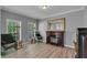 Cozy living room featuring a decorative fireplace, two windows, wood floors and neutral gray walls at 4668 Raiders Ridge Ct, Lithonia, GA 30038
