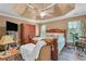 Spacious main bedroom featuring a tray ceiling, a ceiling fan, and an oversized bed set with matching side tables at 4668 Raiders Ridge Ct, Lithonia, GA 30038