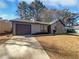 Charming single story home featuring a stone accent wall, garage, and well-maintained lawn at 4673 Hairston Crossing Way, Stone Mountain, GA 30083