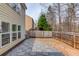 Fenced backyard featuring a stone patio, lush landscaping, and a well-maintained lawn at 1169 Harvest Brook Dr, Lawrenceville, GA 30043