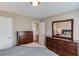 Bedroom with wood dresser, mirror, neutral walls and a door to the ensuite bathroom at 1169 Harvest Brook Dr, Lawrenceville, GA 30043