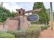 A stone and brick monument sign for Kensington Creek Manor nestled among lush landscaping at 1169 Harvest Brook Dr, Lawrenceville, GA 30043