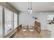 Dining room with an elongated wooden table set for four, modern lighting, and large windows providing natural light at 1169 Harvest Brook Dr, Lawrenceville, GA 30043