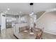 Open concept dining area adjacent to the kitchen with a wooden table and views of the living space and staircase at 1169 Harvest Brook Dr, Lawrenceville, GA 30043