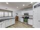 Bright kitchen featuring white cabinets, stainless steel appliances, black countertops, and modern lighting fixtures at 1169 Harvest Brook Dr, Lawrenceville, GA 30043