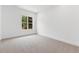 Bright bedroom with plush neutral carpeting, white walls, and a window showing lush greenery at 2140 Parkside Ln, Roswell, GA 30076
