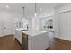 Elegant kitchen featuring a large island with a sink, modern lighting, and views into the living room at 2140 Parkside Ln, Roswell, GA 30076